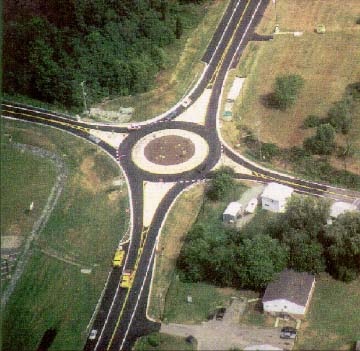 photo: aerial view of a four way intersection with roundabout