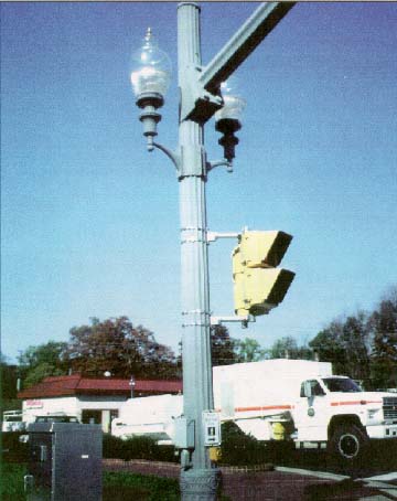 photo: combination light pole and pedestrian crossing signals. truck in the background. 