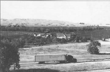 photo: a truck on the Hollister Bypass, San Benito, CA, with Mitchell Fruit Farm in the background