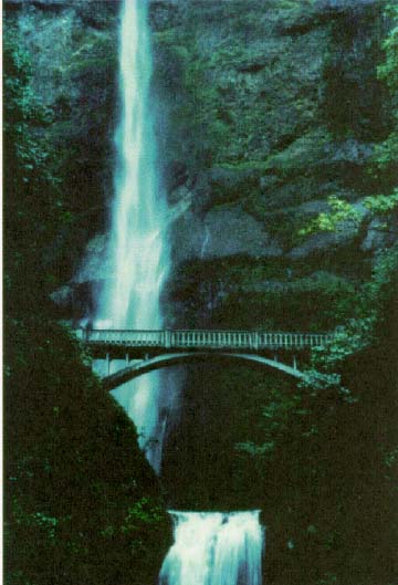 photo: a waterfall behind a bridge