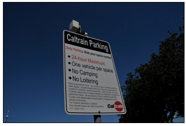 Photo of a Caltrain Smart Parking 3G transmitter mounted to the top of a post-mounted sign.