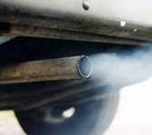 Photograph:    Close up photograph of an automible's exhust pipe.  In the photograph a grayish blue gas is being emitted from the tailpipe.