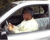 Photograph:    Woman (motorist) driving an automobile.  