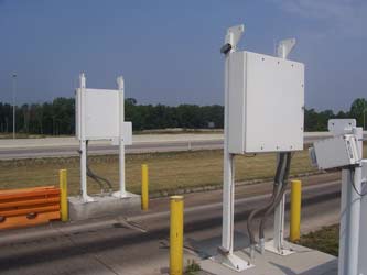 Photograph of raised panels on radiation detector, to left and right of the slow-down lane at Laurel County station.  The laser scanner and electronic light beam vehicle detection hardware is also shown as part of the ISSES apparatus.