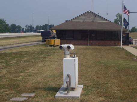 Figure 10. Photograph. Thermal imaging camera pedestal, with scale house in the background (Laurel County, KY).