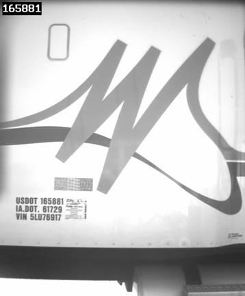 Figure 15. Photograph. Monochrome image of side of a semi tractor cab, showing identifying numbers painted on side, with computer-converted USDOT number superimposed in upper left corner, to illustrate ISSES DOT number reader output.