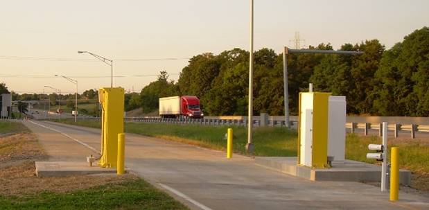 Figure 4. Photograph. View of reduced-height radiation portal panels and more compact ISSES installation at Simpson County, Kentucky, weigh station.  The license plate cameras are on the driver (highway) side of the portal lane.
